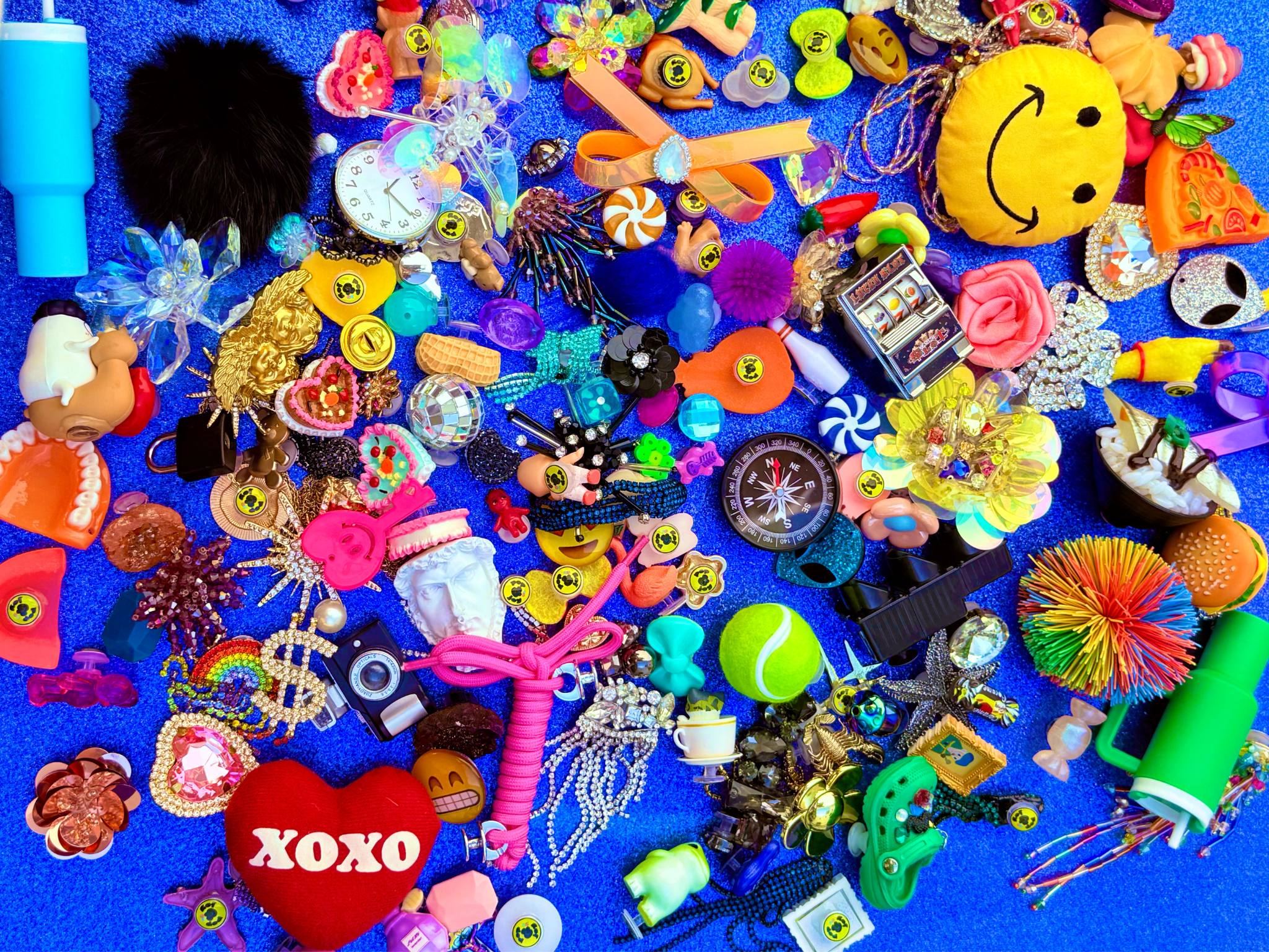 Assorted colorful toys and trinkets on a blue glittery background